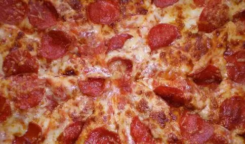 Pepperoni pizza casera con mozzarella derretida y pepperoni crocante estilo americano.
