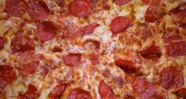 Pepperoni pizza casera con mozzarella derretida y pepperoni crocante estilo americano.