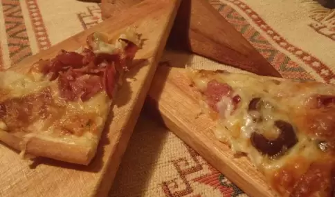 Pizza calabresa casera, con masa esponjosa, mozzarella derretida y salame picante.