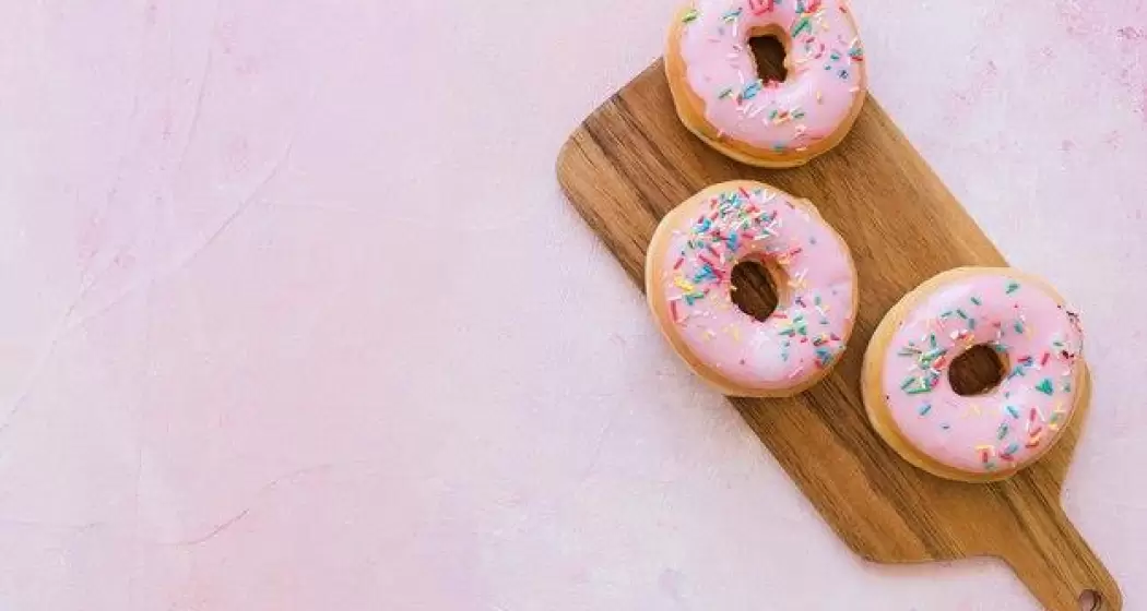 overhead-view-two-fresh-pink-donuts-wooden-chopping-board_23-2147909350