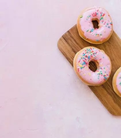 overhead-view-two-fresh-pink-donuts-wooden-chopping-board_23-2147909350