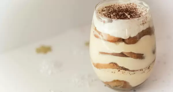 Delicioso postre en capas con vainillas, crema y cacao en polvo.