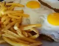 Milanesas a caballo con salsa, queso, jam�n y huevo, un plato cl�sico argentino.