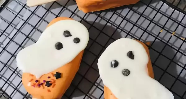 Paletas heladas de bizcochuelo decoradas con fantasmas, perfectas para Halloween.