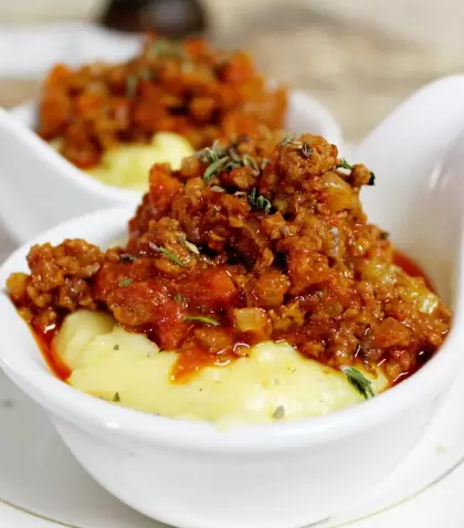 Polenta cremosa con textura suave y reconfortante.