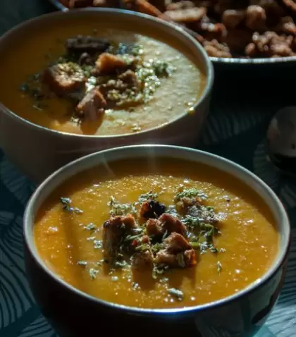 Deliciosa sopa de calabaza servida en tazones con crutones, perfecta para una acogedora comida de oto�o.