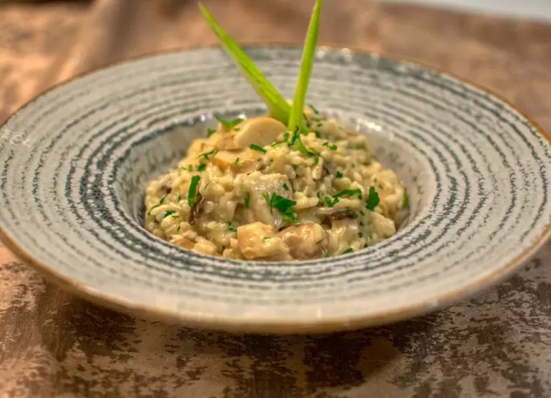 Un risotto casero, suave, con hongos bien dorados.